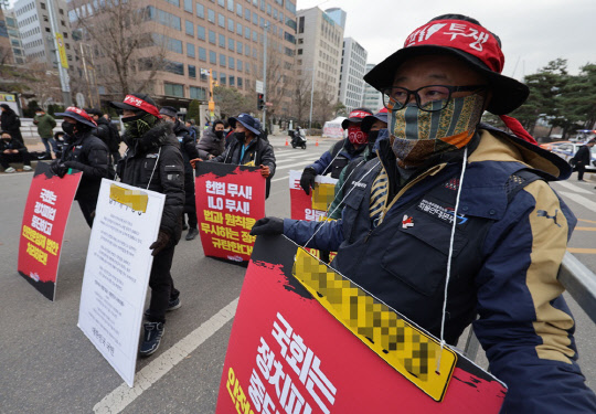 7일 오후 서울 여의도 국회 앞에서 민주노총 주최로 열린 생명안전 후퇴 윤석열 정부 규탄! 노동자 참여 입법 촉구! 민주노총 결의대회에서 화물노동자들이 번호판을 목에 걸고 집회에 참여하고 있다.<연합뉴스>